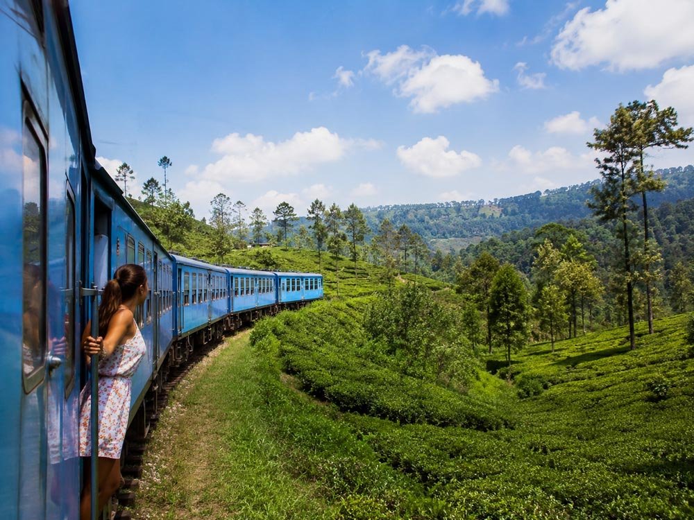 Train passing through green hill country in Sri Lanka