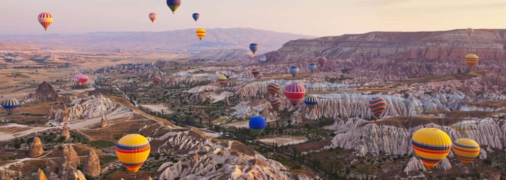 Hot air balloons over Cappadocia fairy chimneys at sunrise, Turkey