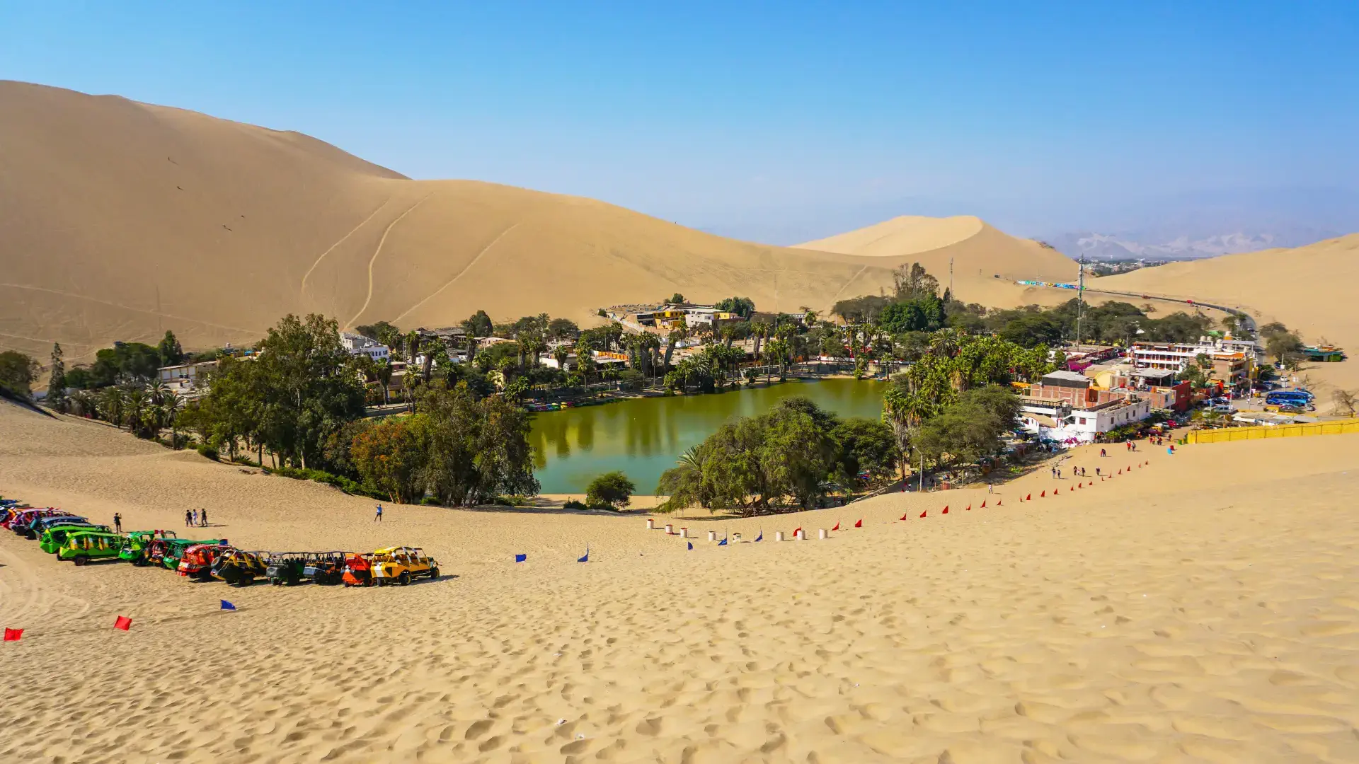 Huacachina desert oasis lagoon surrounded by sand dunes in Ica Peru