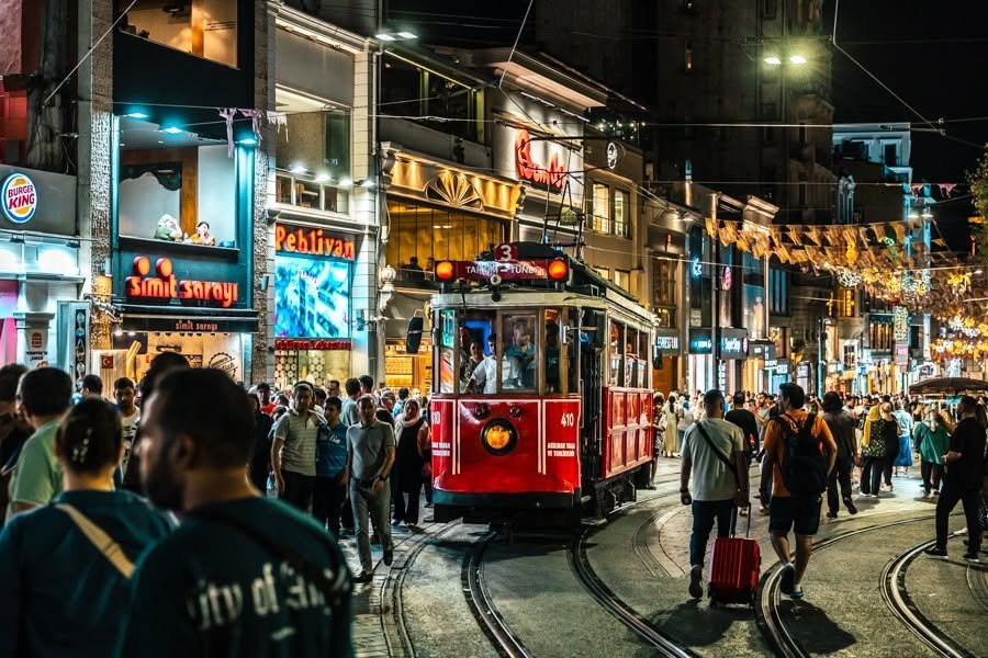 Historic tram on Istiklal Caddesi at night in Istanbul, crowds of pedestrians