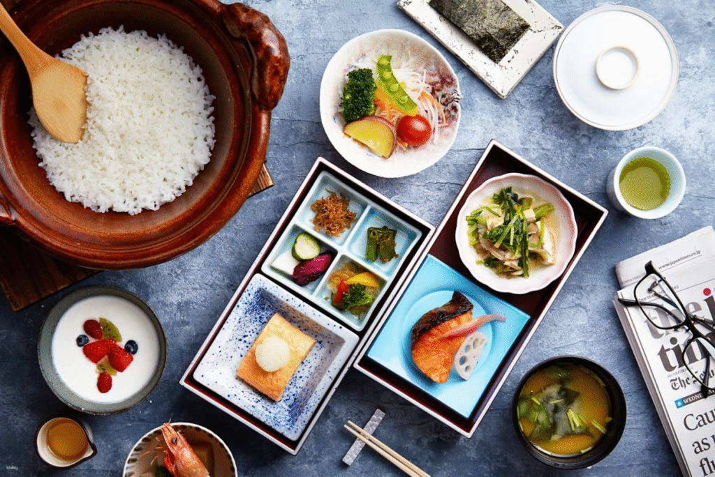 Traditional Japanese kaiseki multi-course meal spread with rice, vegetables, fish and green tea in Kyoto
