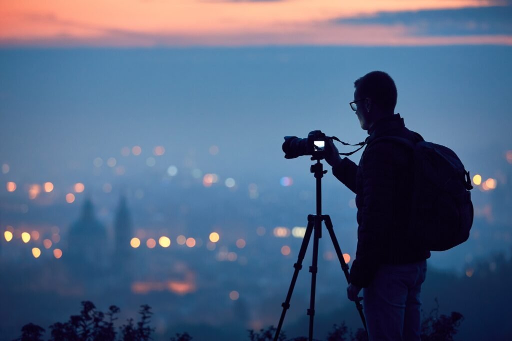 travel photographer silhouette with tripod shooting at blue hour - light tips for travel photography beginners