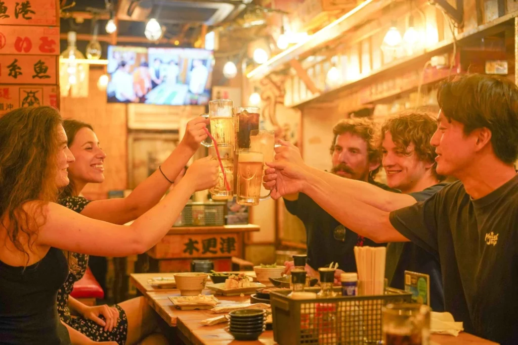 Friends drinking at a tiny bar in Shinjuku Golden Gai, Tokyo
