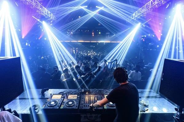 DJ performing at Womb nightclub in Shibuya, Tokyo with laser lights