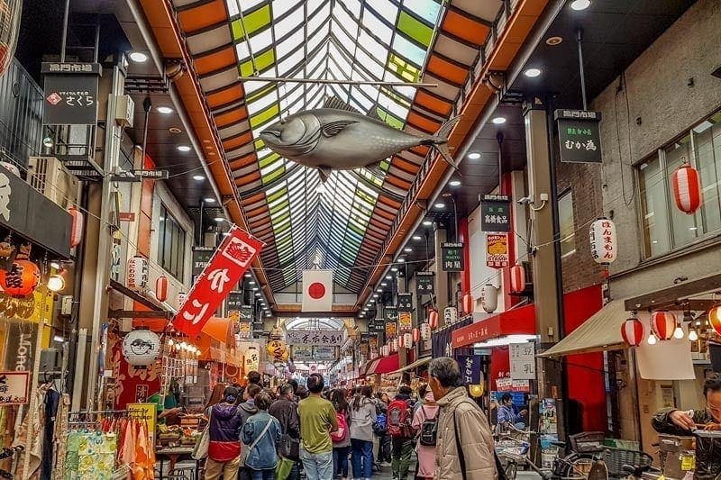 Kuromon Ichiba covered market arcade in Osaka with fresh seafood stalls and red lanterns - Japan travel guide
