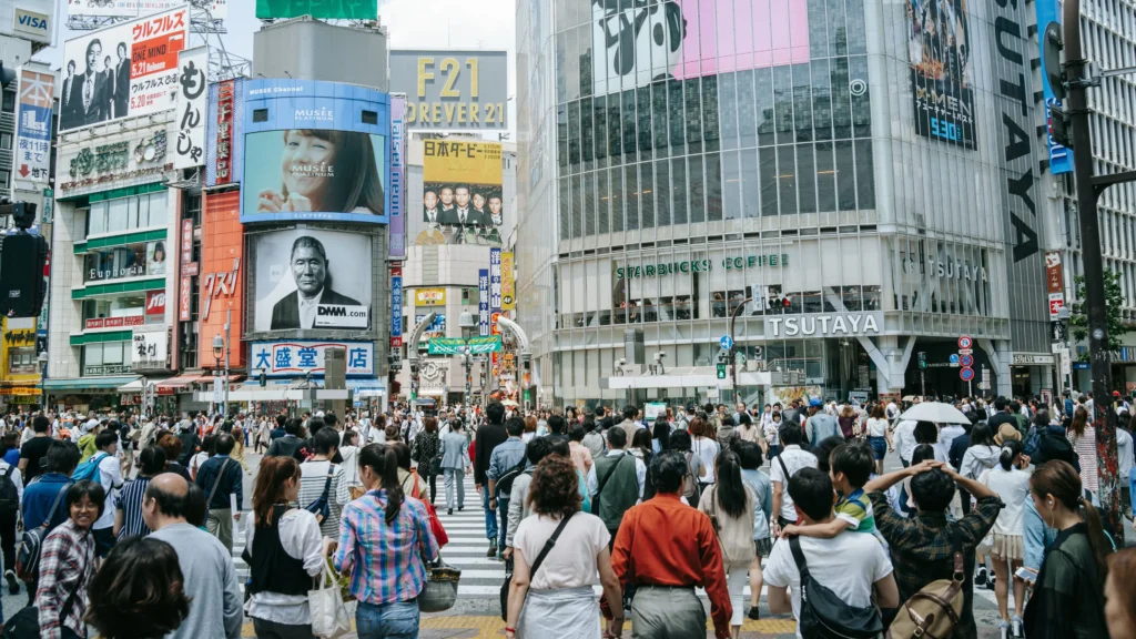Crowds crossing Shibuya scramble intersection in Tokyo - Japan travel guide